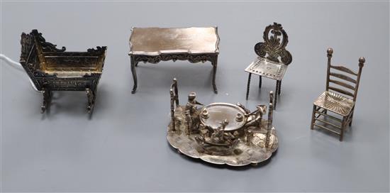 Five assorted continental white metal miniature items including a Dutch embossed cradle and a similar Dining group, cradle 58mm.